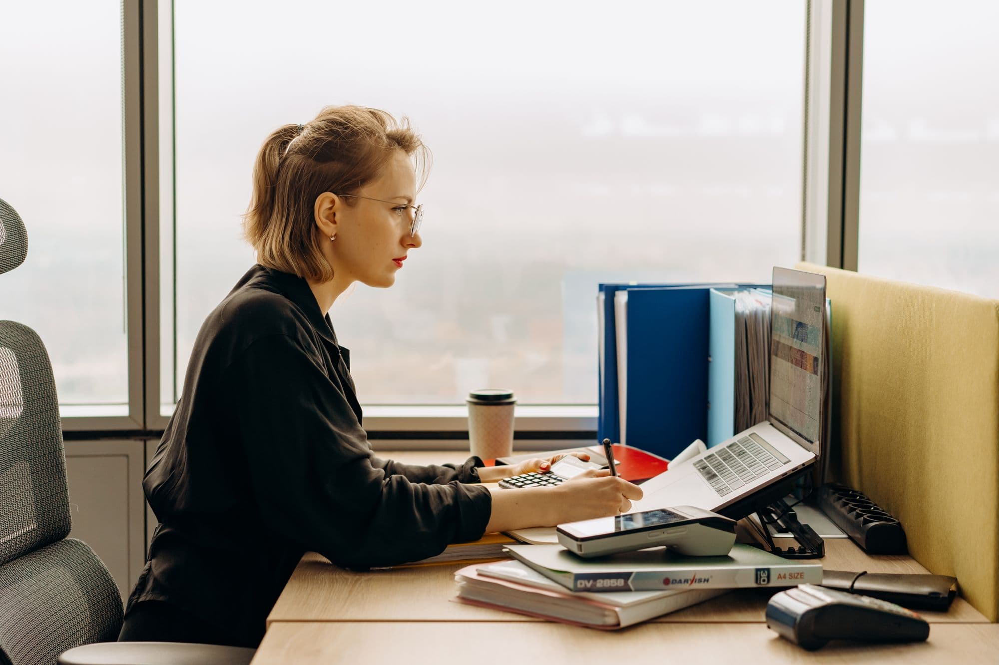 Accountant working at a desk by a window